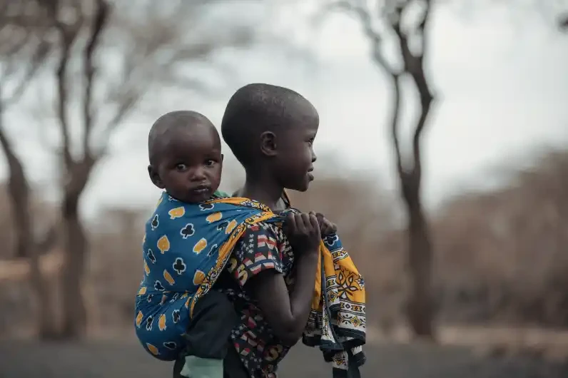 Sisterly Strength: A Young Girl Carrying Hope in Kenya